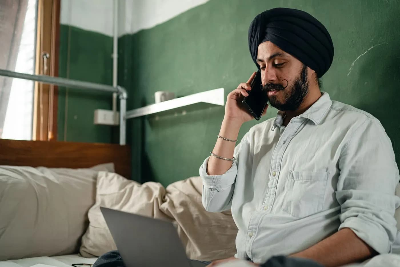 Man on a phone call while working on a laptop