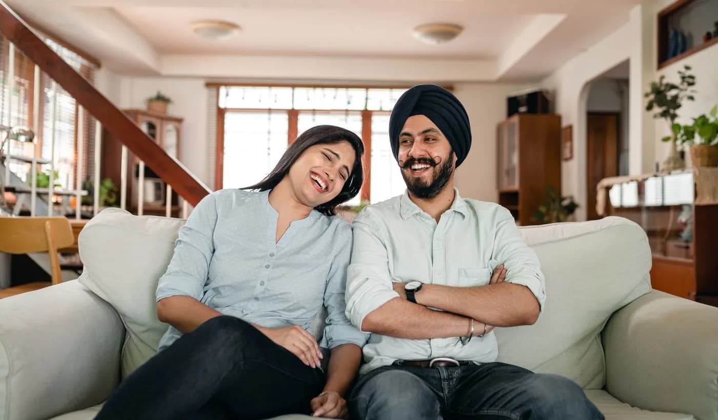 Young couple laughing together on a sofa